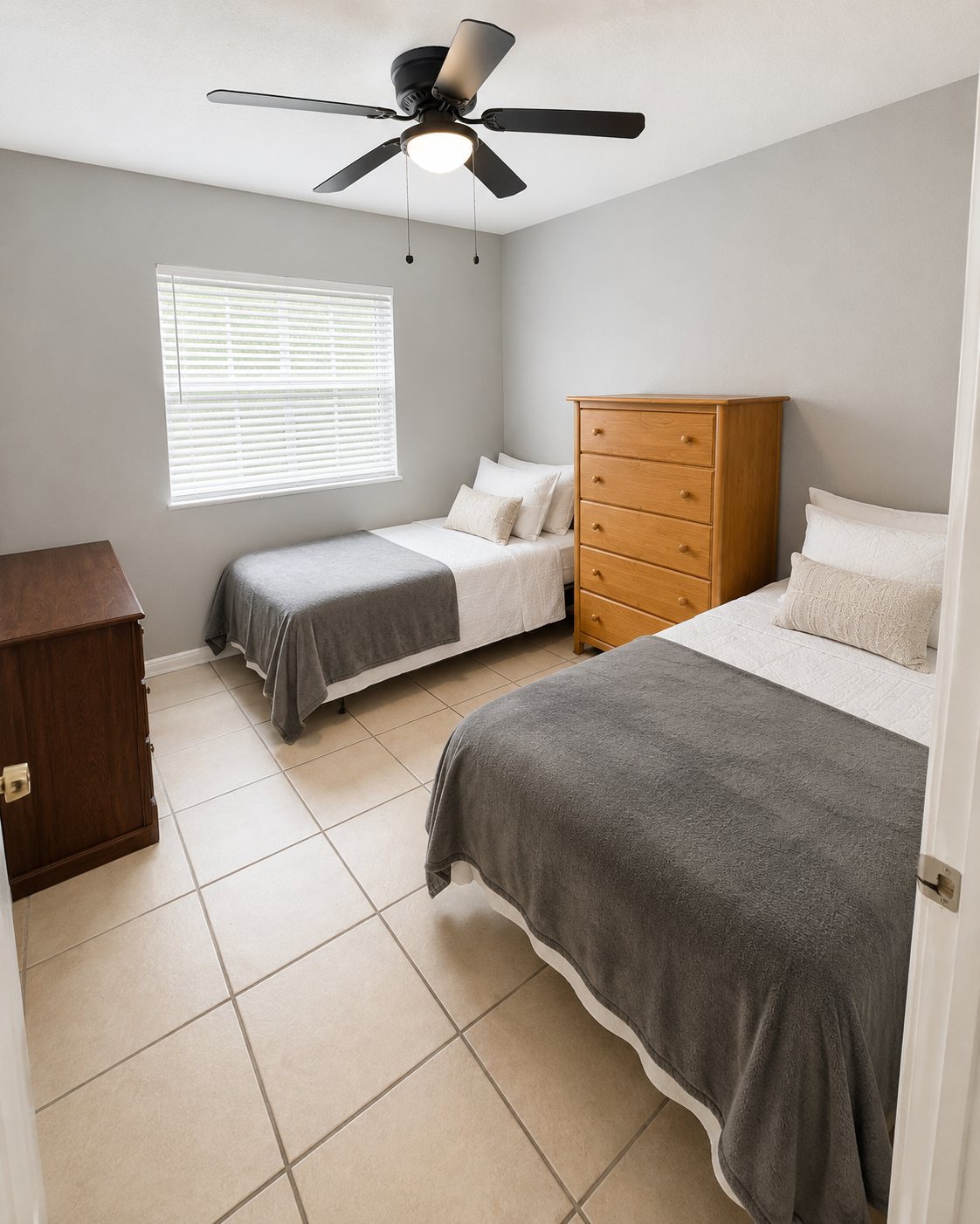Clean shared bedroom with two beds and dressers