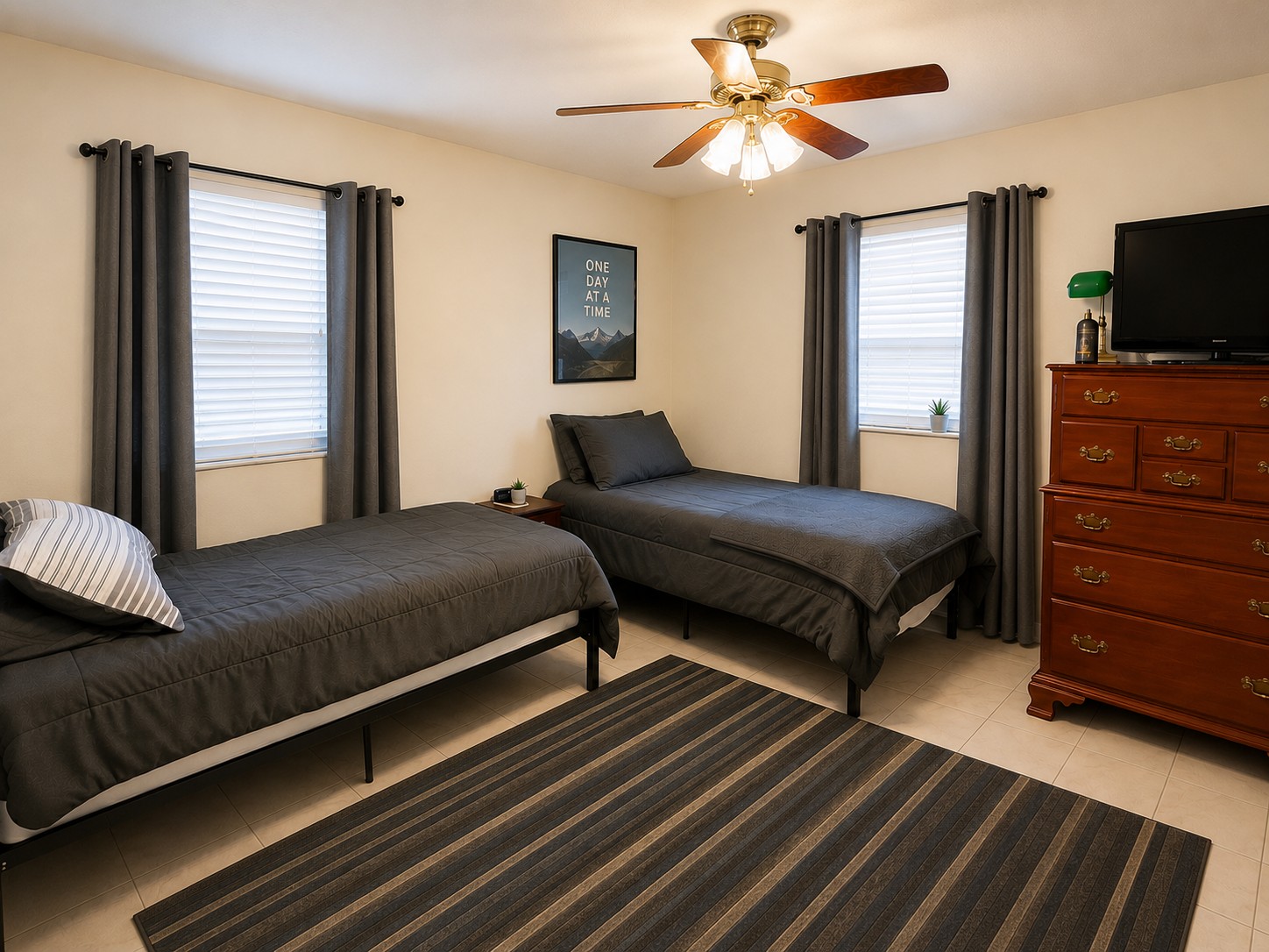 Shared bedroom with two gray beds, curtains, and a dresser