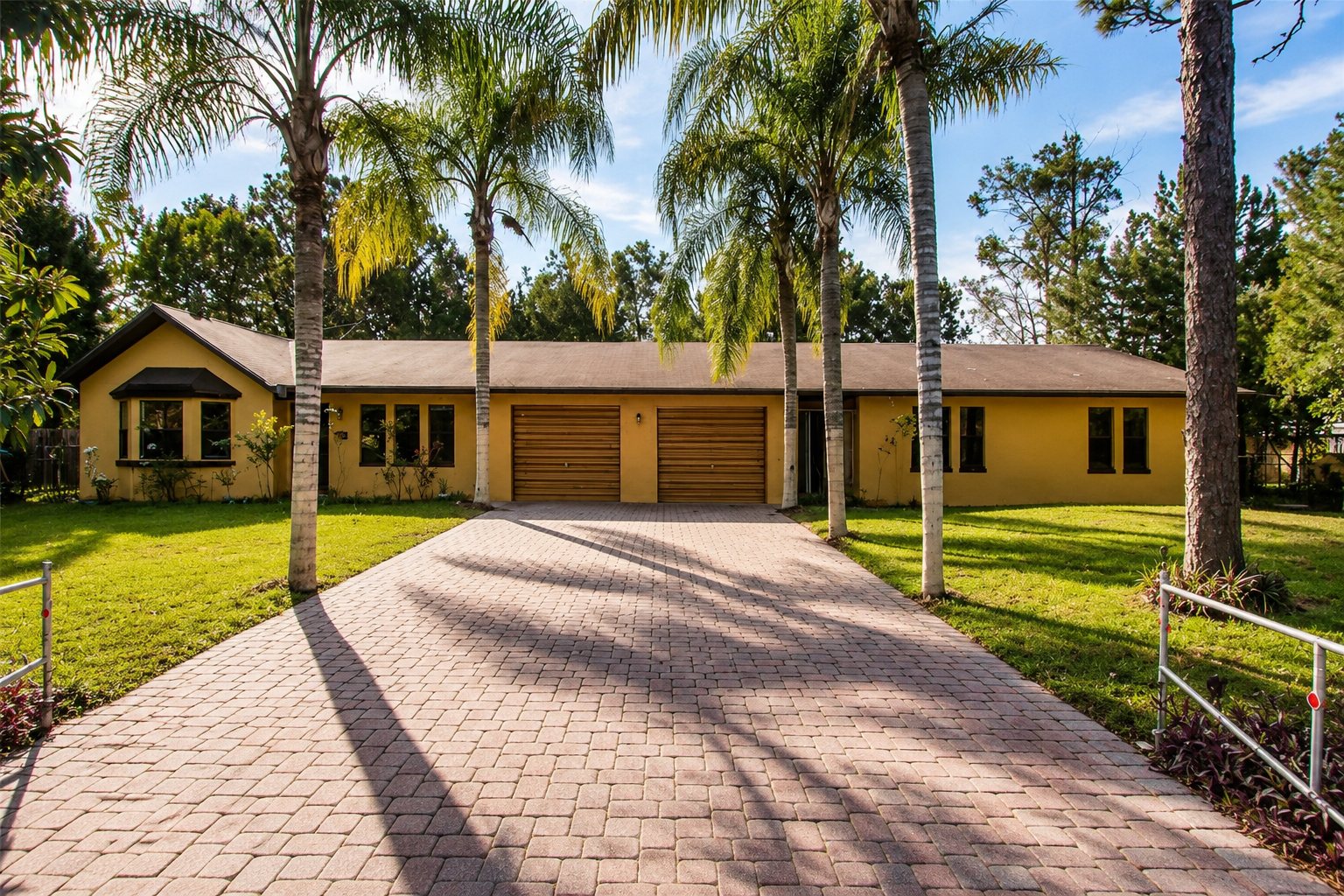 A Steadfast Recovery sober living home with palm trees and a wide driveway