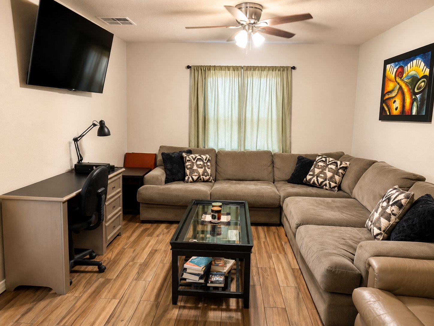 Comfortable living room with desk, couch, and television